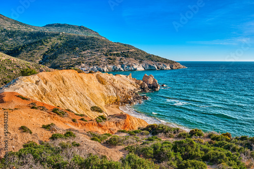 Sunset over beach, cliffs and hills and deep azure sea. Agios Ioannis
