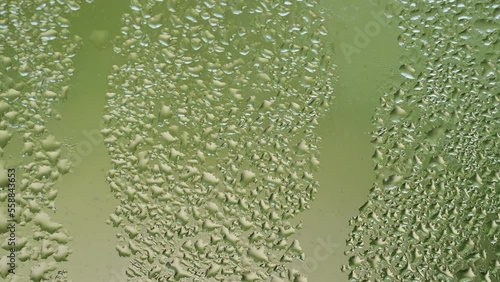 Timelapse water falling by drops through a windows.