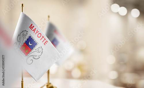 Small flags of the Mayotte on an abstract blurry background photo