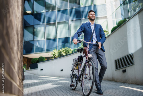 Fototapet Happy middle age caucasian stylish businessman going to work by bike