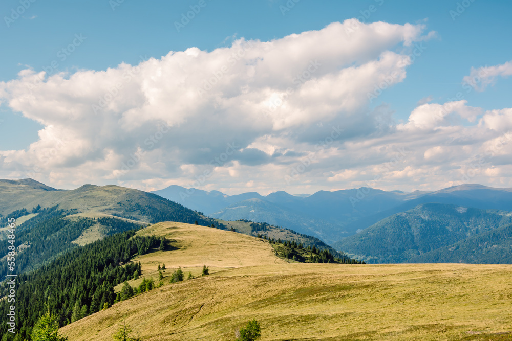 Alpine summer landscape in the Nock Mountains national park, the national park is characterized by peaceful hilly mountains covered with grassy meadows, Gurktal Alps, Austria. Alpine summer landscape in the Nock Mountains national park, the national park is characterized by peaceful hilly mountains covered with grassy meadows, Gurktal Alps, Austria.