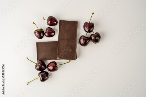 Flat lay of English Morello Cherries on a herringbone pattern  dark chocolate isolated on a  white  background photo