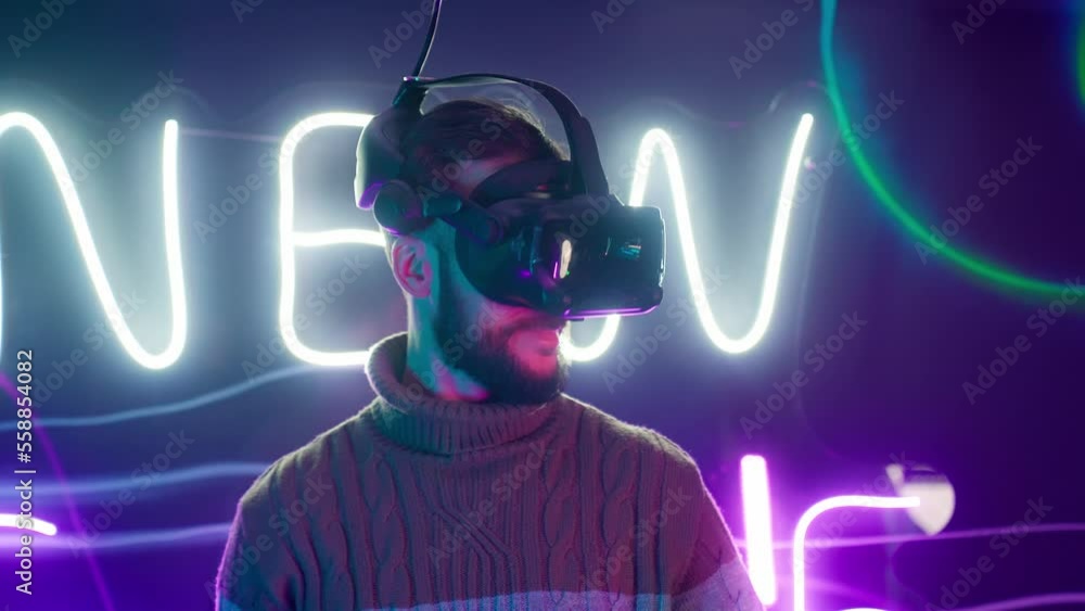 Cyber gamer in VR glasses plays virtual reality game in neon futuristic space. Cyberpunk fashion gaming concept. Man and woman play metaverse virtual digital technology game control with VR goggle. Cyber gamer in VR glasses plays virtual reality game in neon futuristic space. Cyberpunk fashion gaming concept. Man and woman play metaverse virtual digital technology game control with VR goggle.