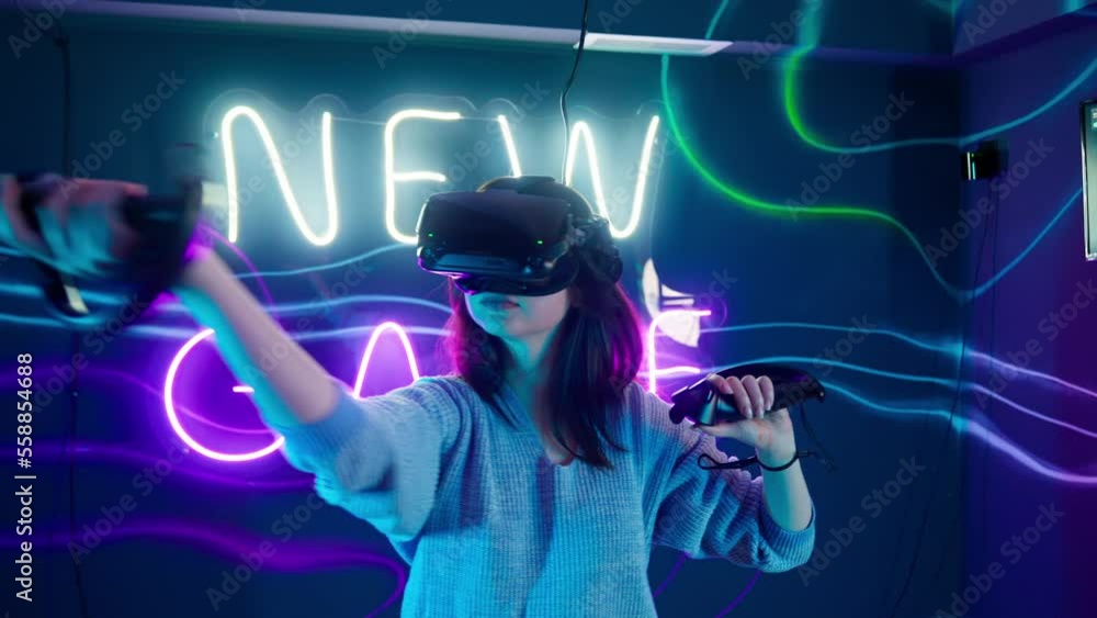 Cyber gamer in VR glasses plays virtual reality game in neon futuristic ...