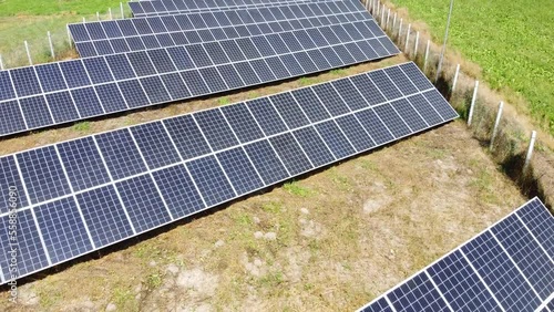 Aerial view of solar power plant on green field. Electric panels for producing clean ecologic energy.