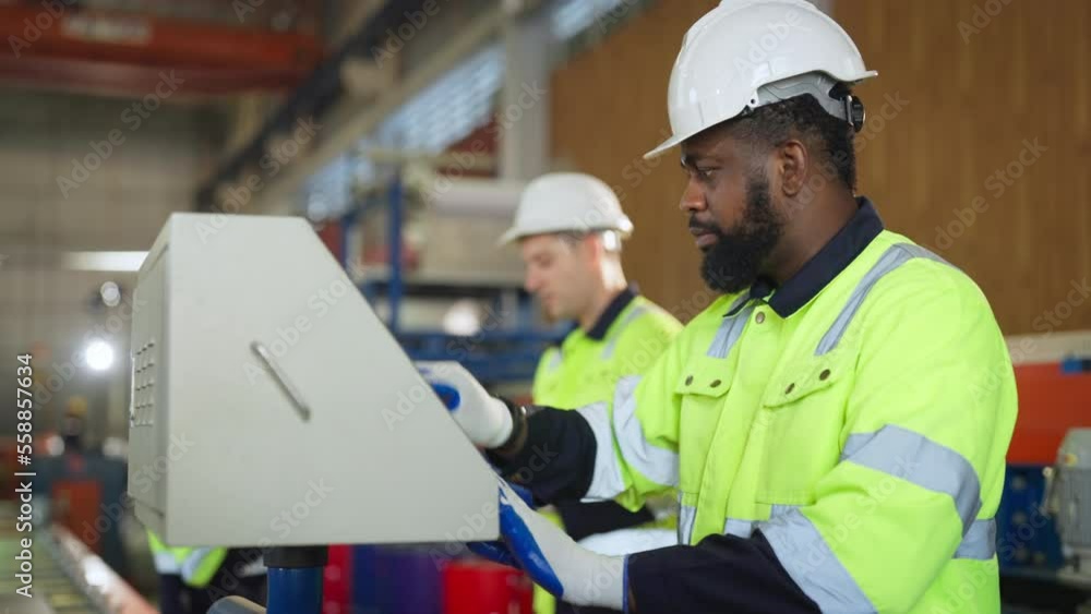 Male engineer is programming a CNC milling machine at modern factory. Industrial plant engineers plan machine maintenance. Male engineer is programming a CNC milling machine at modern factory. Industrial plant engineers plan machine maintenance.
