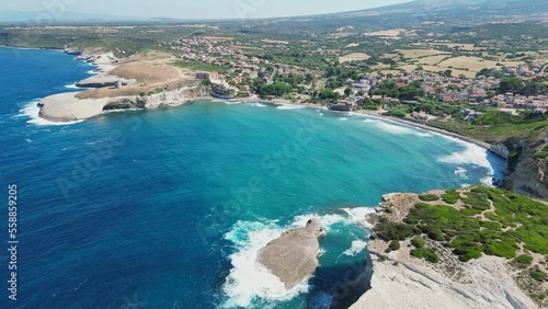 S' Archittu beach town and rocky cliffs along west coast of Sardinia - 4k Aerial backwards