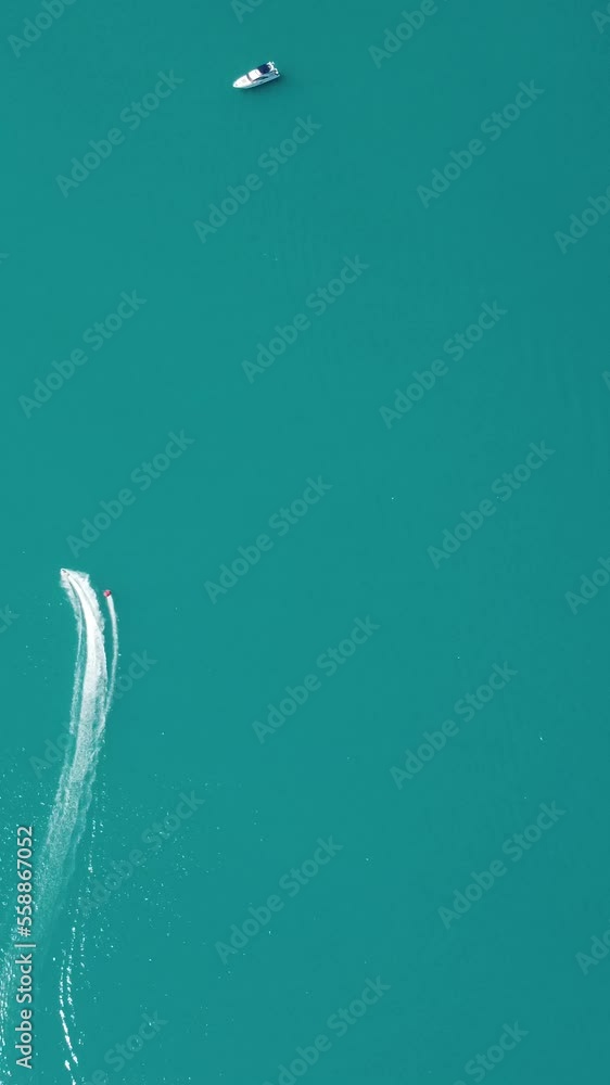 High speed water bike leaving abstract white footprints on the sea water. Aerial top view on Water scooter. Amazing nature background. Water color are beautifully vibrant. Fresh freedom. Adventure day High speed water bike leaving abstract white footprints on the sea water. Aerial top view on Water scooter. Amazing nature background. Water color are beautifully vibrant. Fresh freedom. Adventure day