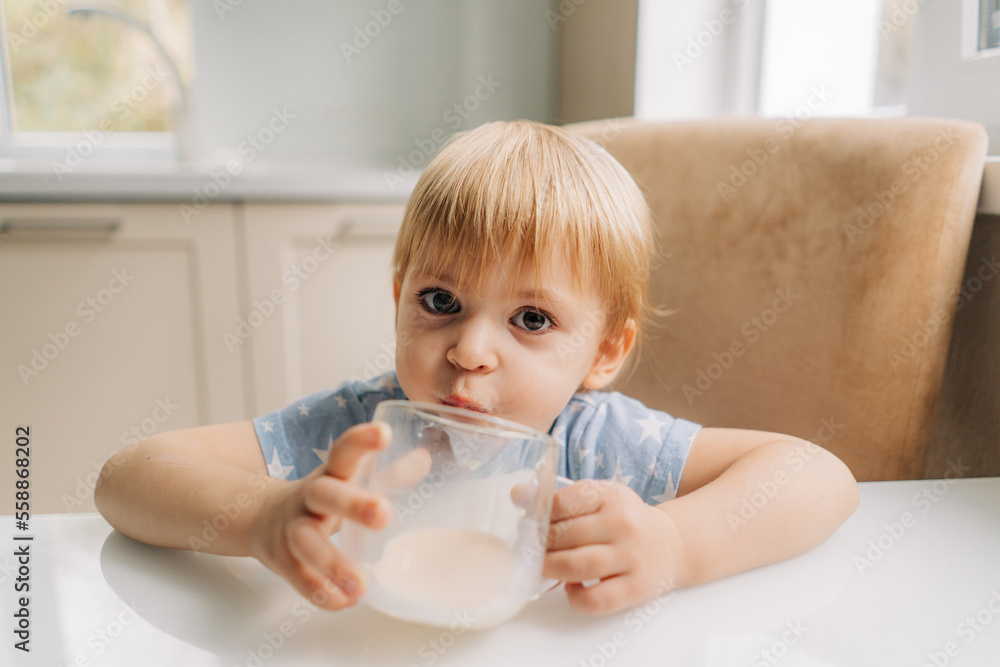 Portrait of happy little girl holding glass of milk, cute child drink fresh dairy product every day Portrait of happy little girl holding glass of milk, cute child drink fresh dairy product every day