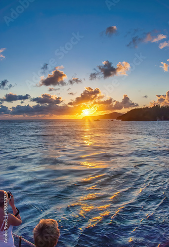 Tourists enjoy a colorful sunset over a beautiful tropical island