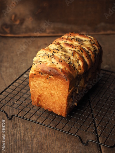 brioche babka loaf with sweet sesame and coconut filling on wooden background
