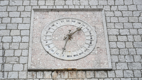 Ancient stone clock on the wall. Old 24-hour clock.