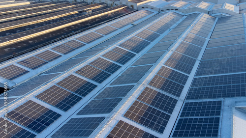Fly over Solar cells on the roof of a large industrial factory. Solar roofs are generating renewable energy for the industry. The goal is to reduce the cost of electricity.