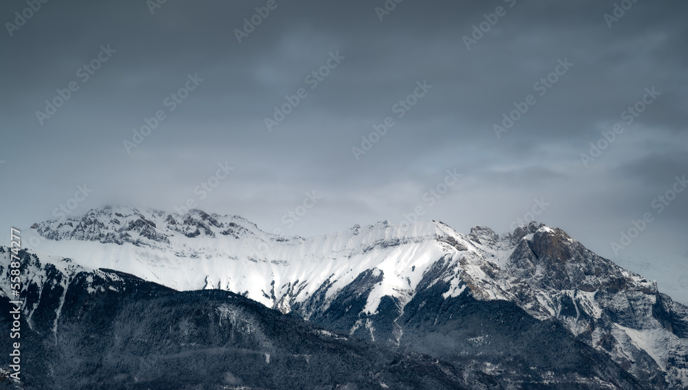 Mountain landscape. Cold mountain. Alps at sunset. Towering blue cloud.Glacier in the mountains.Panorama on top of a snowy mountain near Saint Jean de Maurienne. Saint Jean de Maurienne in the French 
