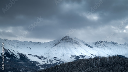 Mountain landscape. Cold mountain. Alps at sunset. Towering blue cloud.Glacier in the mountains.Panorama on top of a snowy mountain near Saint Jean de Maurienne. Saint Jean de Maurienne in the French 