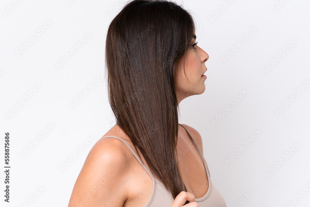 Young Brazilian woman isolated on white background touching her hair. Close up portrait