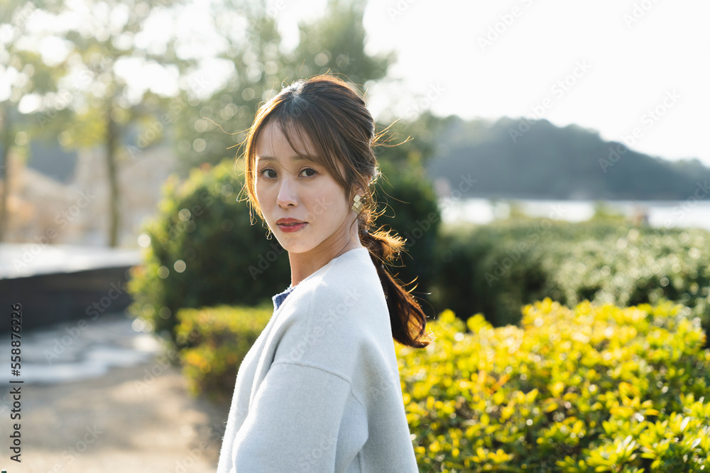 公園で爽やかな光を浴びる女性