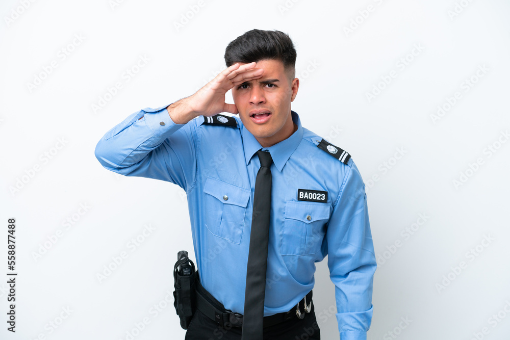 Young police caucasian man isolated on white background looking far away with hand to look something Young police caucasian man isolated on white background looking far away with hand to look something