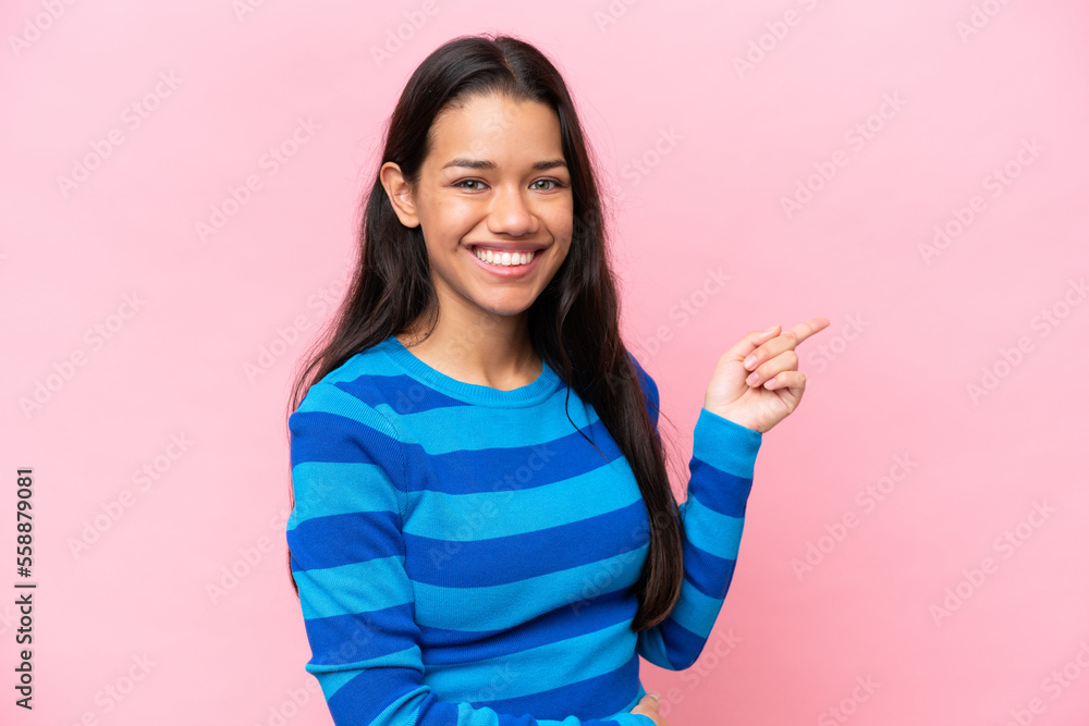 Young Colombian woman isolated on pink background pointing finger to the side Young Colombian woman isolated on pink background pointing finger to the side