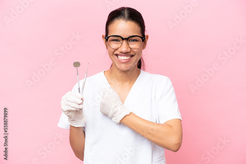 Dentist Colombian woman isolated on pink background celebrating a victory