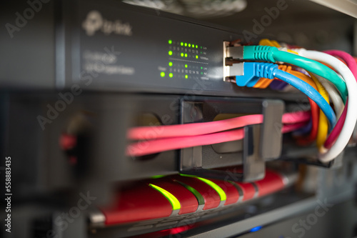 Foto Router and switch with colorful LAN cables in a network cabinet of a data center