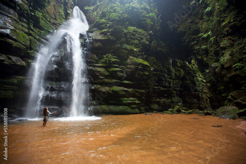 A woman observes a waterfall in Brazil. photo