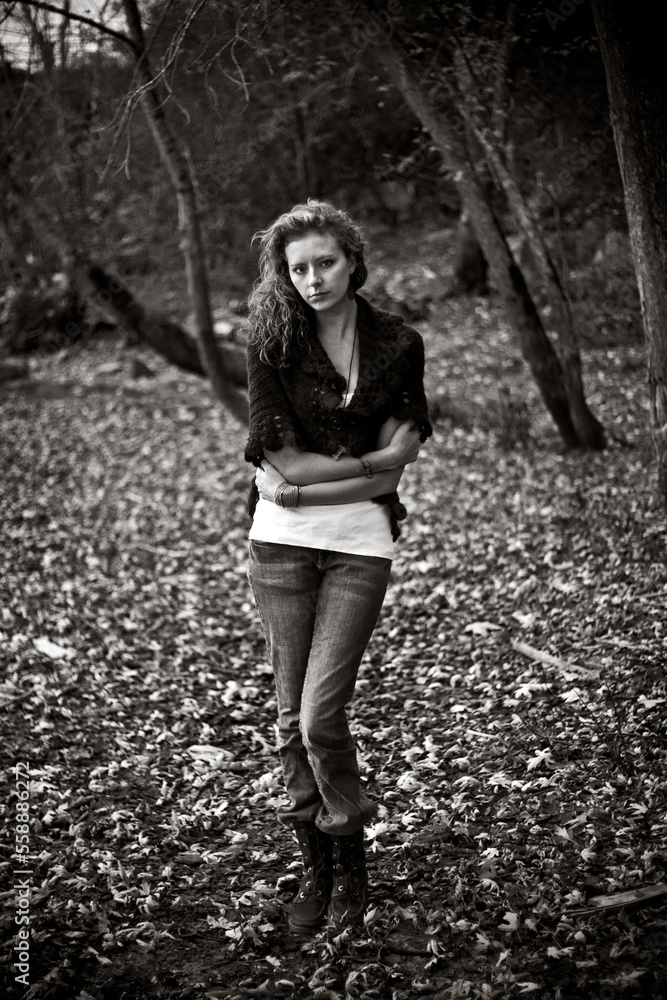 A portrait of a young woman with curly hair wearing a sweater in fall. A portrait of a young woman with curly hair wearing a sweater in fall.