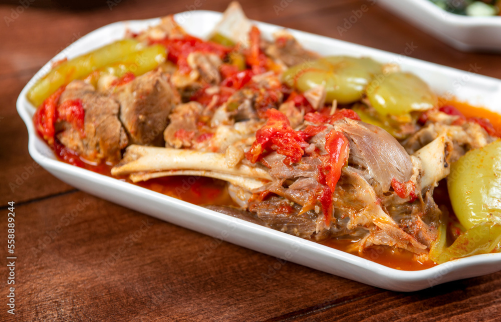 stewed lamb on the bone with vegetables on wooden desk stewed lamb on the bone with vegetables on wooden desk