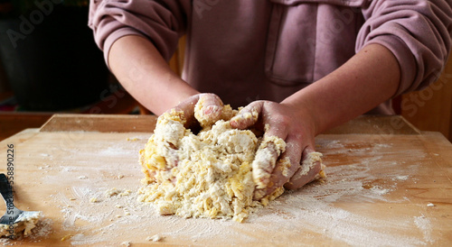 young caucasian female hands kneading shortcrust pastry for sweet tarte