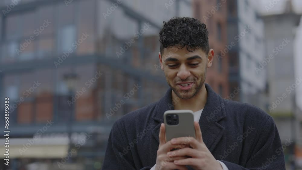 Excited man holding mobile standing outdoors reading email on smartphone with good news. Male happily celebrating winning in the lottery. Winter time Excited man holding mobile standing outdoors reading email on smartphone with good news. Male happily celebrating winning in the lottery. Winter time
