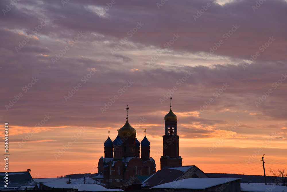 Orthodox church on the background of a beautiful red sunset. Landscape of a Christian church in the evening.