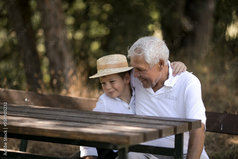 Fototapeta premium Happy senior man Grandfather with cute little boy grandson playing in forest