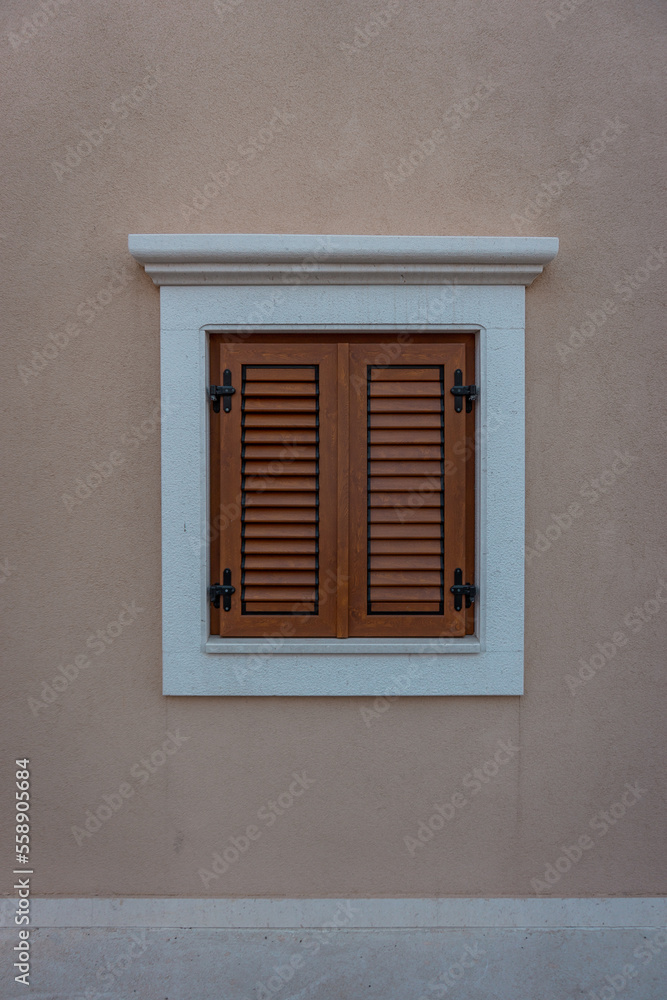Fototapeta premium Kleines Fenster am Haus mit Fensterläden. 