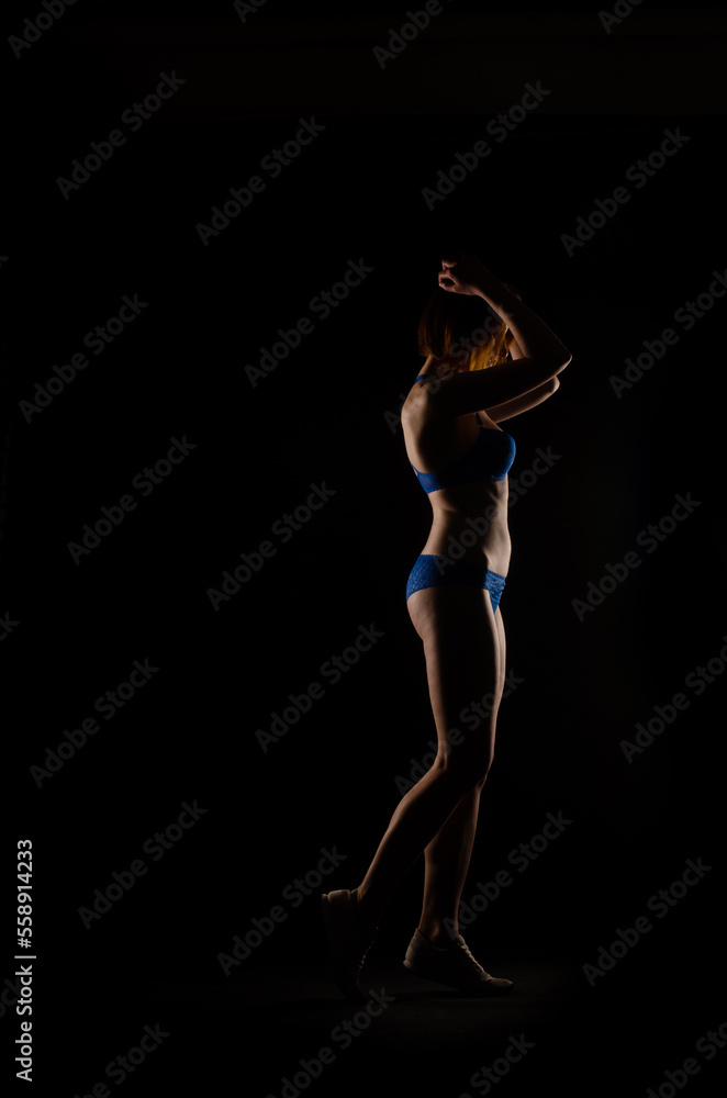 Beautiful female body in black linen on a dark background