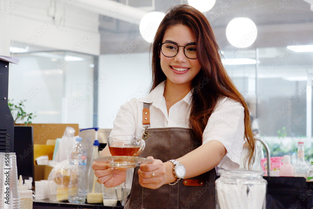 Coffee shop worker holding a cup of hot tea. Coffee shop worker holding a cup of hot tea.