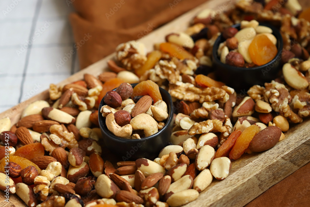 Mix of nuts and dried fruits on a wooden board and in a bowl. Healthy sweets. Mix of nuts and dried fruits on a wooden board and in a bowl. Healthy sweets.