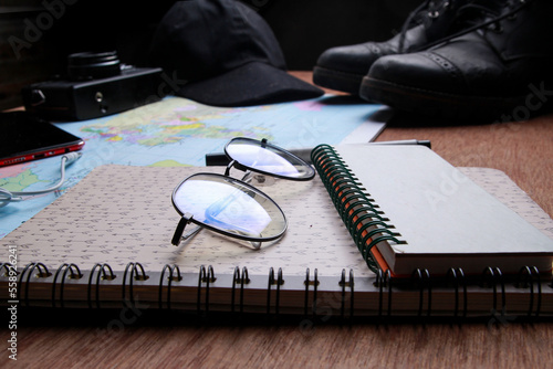 Travel equipment lies on a wooden table. 
