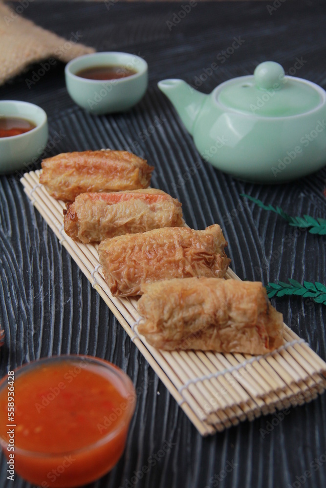 Dimsum, as the name Keicak, is filled with carrots, chicken, mushrooms and wrapped in tofu skin, side angle with black background