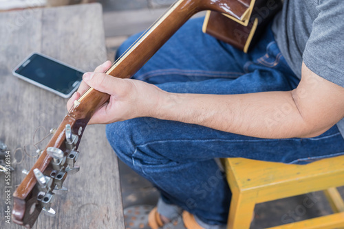 songwriter thinking and writing notes,lyrics in book at studio.man playing live acoustic guitar.concept for musician creative.artist composer in work process.people relaxing time with instrument
Photo