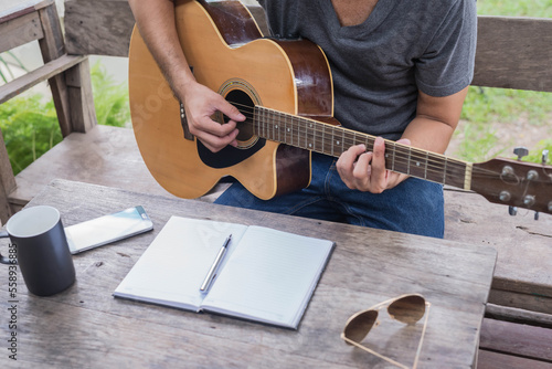 songwriter thinking and writing notes,lyrics in book at studio.man playing live acoustic guitar.concept for musician creative.artist composer in work process.people relaxing time with instrument
Photo