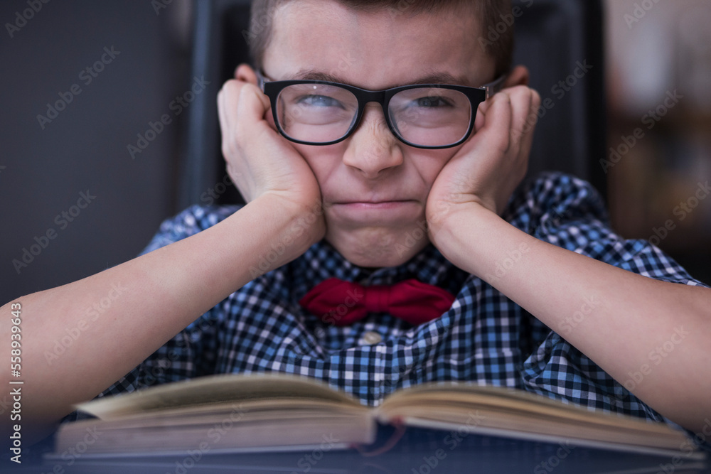 A very cute boy is studying and writing his homework A very cute boy is studying and writing his homework