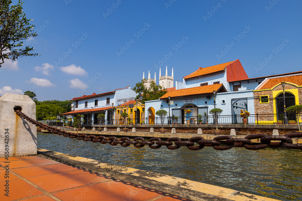 Malacca, Malaysia - August 10, 2022: Along the Melaka river with the old brightly painted houses. Bars and restaurants line the course of the river. Long Exposure capture smooths silky water.