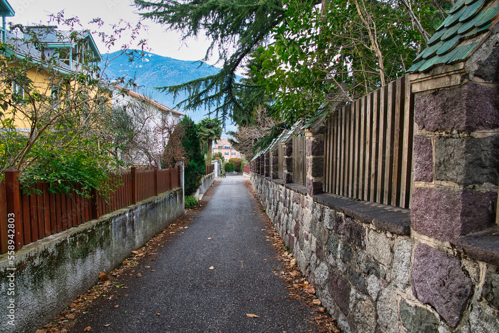 Ein schmaler Weg, zwischen Mauern und Zäunen in Meran, Südtirol