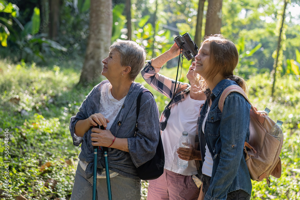 Backpack tourist travel outdoor holiday adventure bird study using binoculars looking bird from tree Backpack tourist travel outdoor holiday adventure bird study using binoculars looking bird from tree