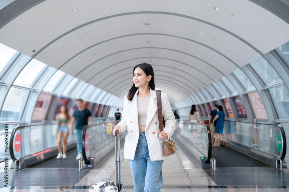 A young beautiful woman walking with suitcase , check in at International airport , vacation travel and transportation concept