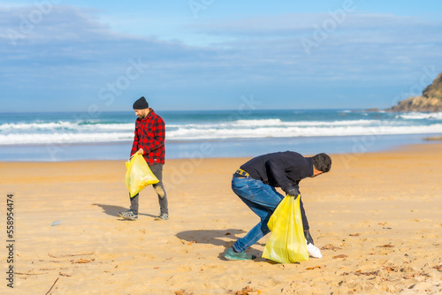 Volunteers collecting plastic on the beach. Ecology concept, sea pollution