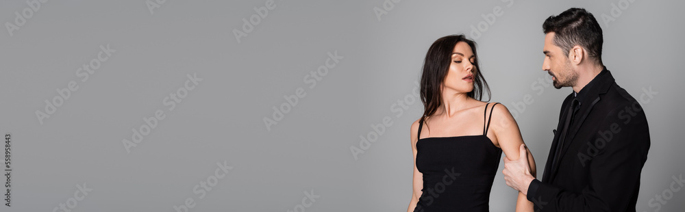 bearded man pulling hand of brunette and sexy woman isolated on grey, banner. bearded man pulling hand of brunette and sexy woman isolated on grey, banner.