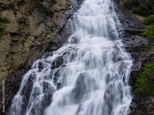 natural waterfall from the rocks in the mountain forest © Andrea