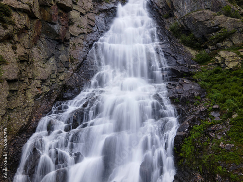 natural waterfall from the rocks in the mountain forest. transparent water