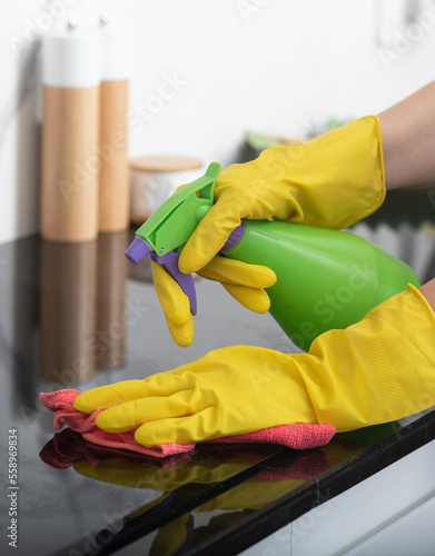 Wallpaper Mural Close up shot of female hands holding bottle spray and rag for cleaning the stove	 Torontodigital.ca
